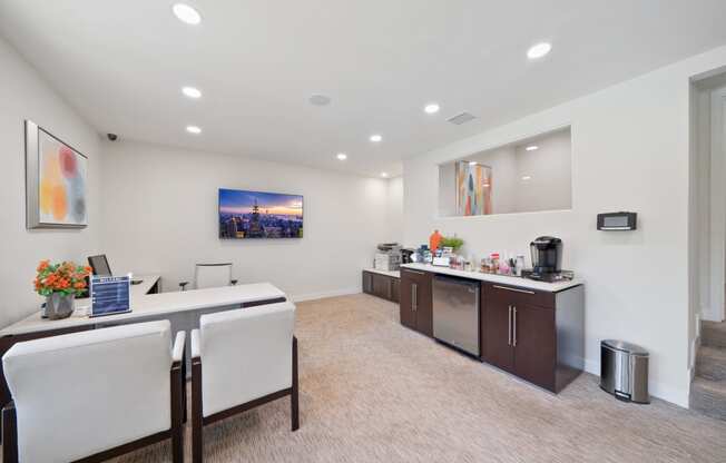 a conference room with two desks and chairs and a counter with a sink