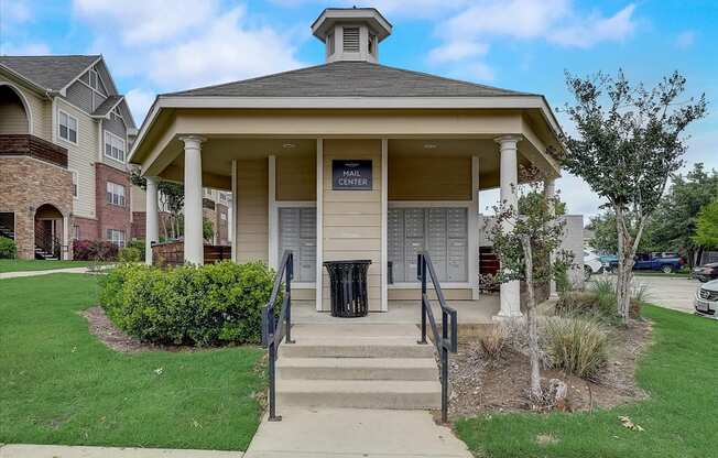 a building with stairs and a trash can in front of it