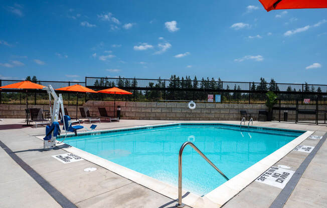 a swimming pool on a sunny day with umbrellas