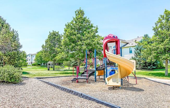 Playground on Mulch in Grassy Courtyard with Building Exterior in the Background