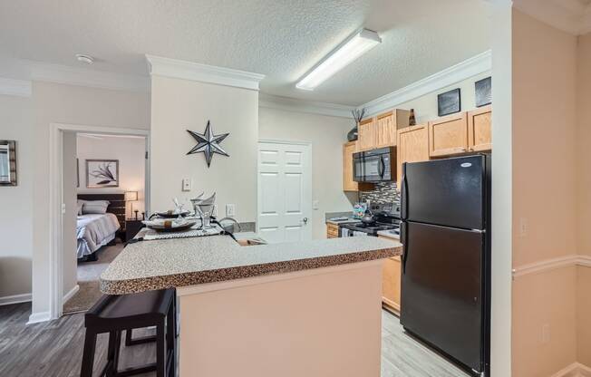 a kitchen with a counter top and a black refrigerator