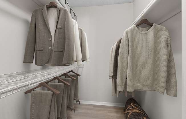 A row of clothes hanging on a rack in a room.