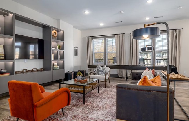 A living room with a red chair and a black couch.