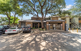 A parking lot with cars and a building in the background.