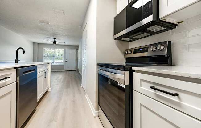 A modern kitchen with stainless steel appliances and white cabinets.
