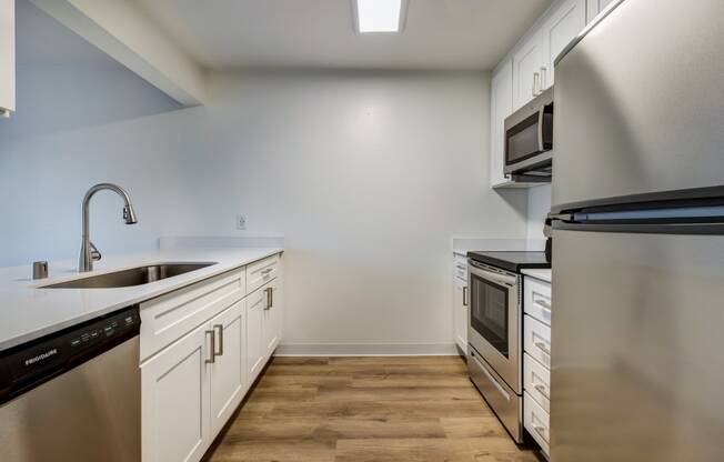 Apartments in Everett for Rent - Woodbrook - Kitchen with Wood-Style Flooring, White Countertops, White Cabinets, and Stainless Steel Appliances