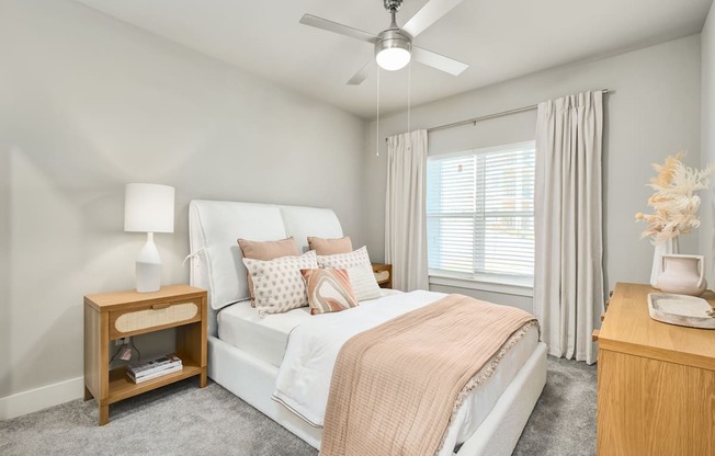 A bedroom with a bed, nightstand, and a ceiling fan at The Ashton at East Park Apartments, Kennesaw, GA, 30144