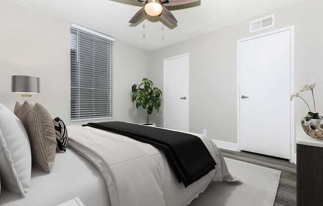 A bedroom with a large bed and a ceiling fan.