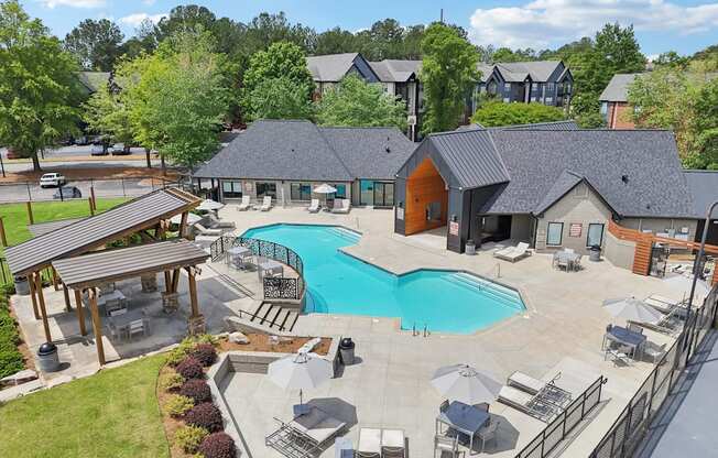 A large outdoor swimming pool surrounded by lounge chairs and umbrellas.