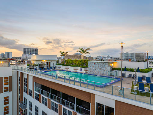 a pool on the roof of a building with a city in the background