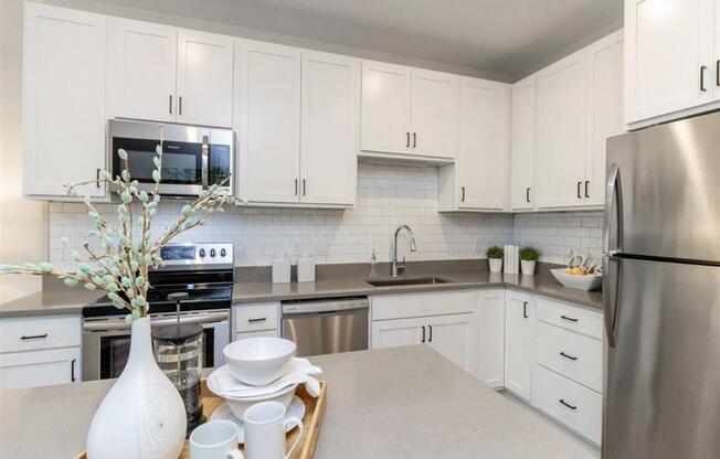 large kitchen with white cabinets, stainless steel appliances and island