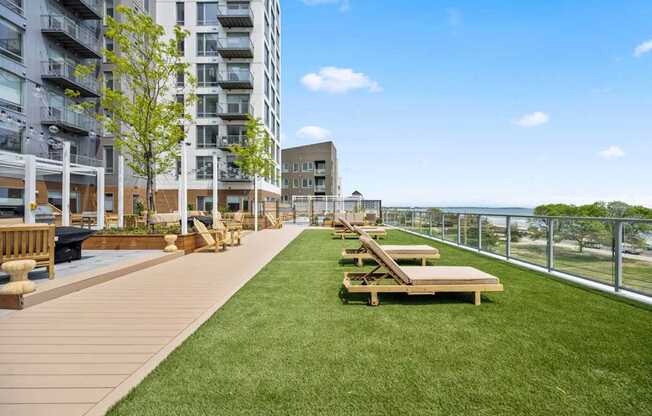 A grassy area with benches and a fence in front of a building.