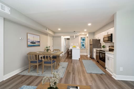 a living room and kitchen with a table and chairs