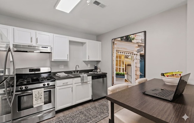 A modern kitchen with a stainless steel stove and white cabinets.