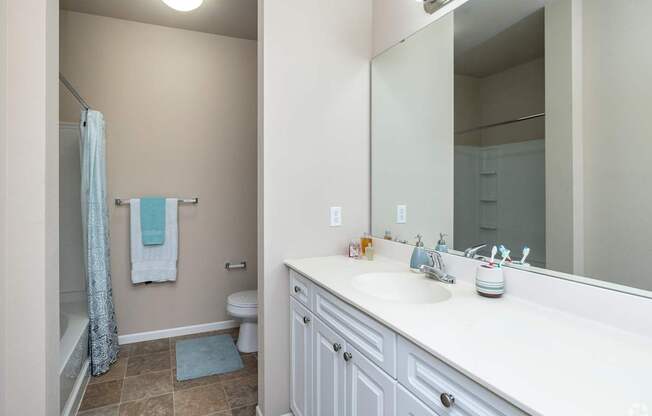 A bathroom with a white sink and a white toilet.