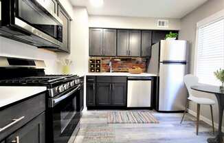 a kitchen with black cabinets and white appliances