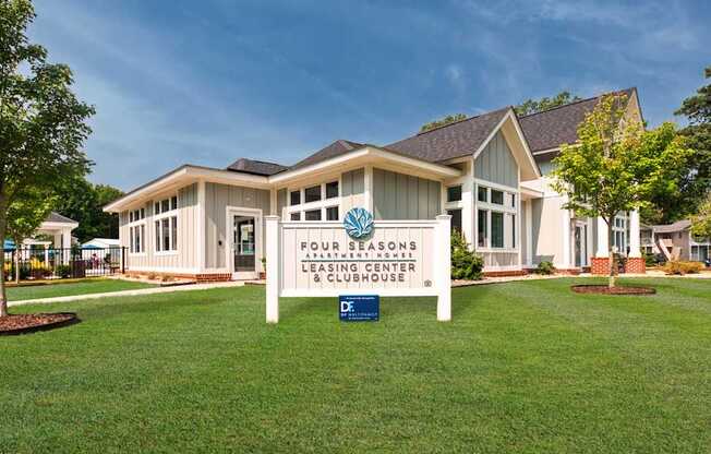 A building with a sign that says "Four Seasons Leasing Center & Clubhouse".