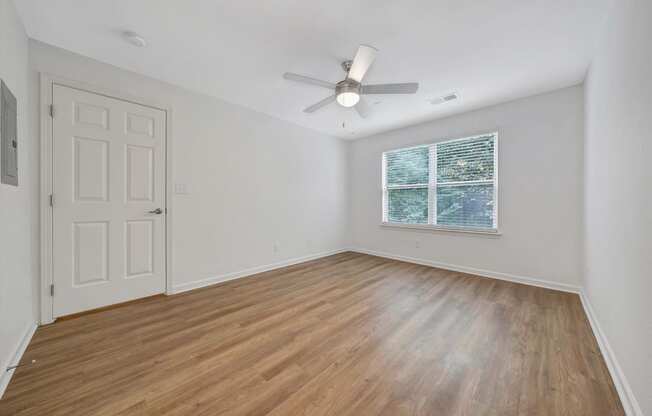 a bedroom with hardwood floors and a ceiling fan