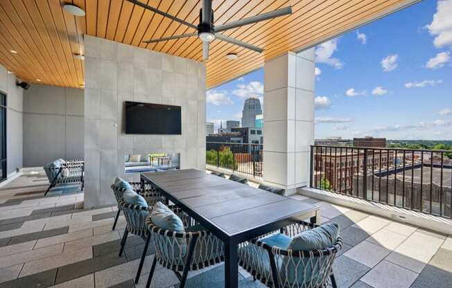 a patio with a table and chairs and a tv at Link Apartments® 4th Street, Winston-Salem, North Carolina