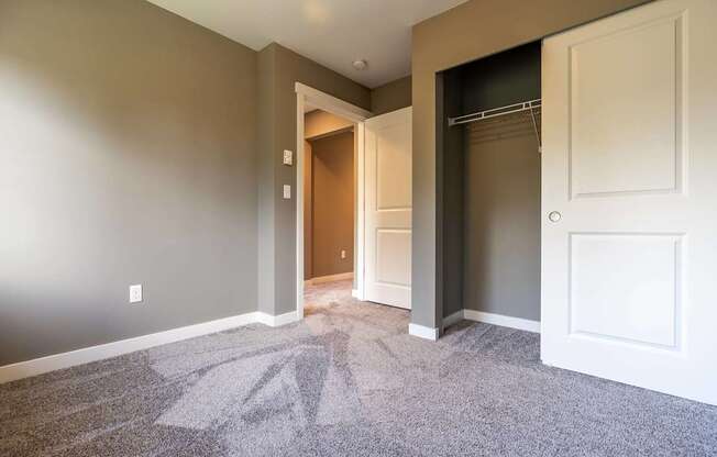 A room with a carpeted floor and a doorway leading to another room.