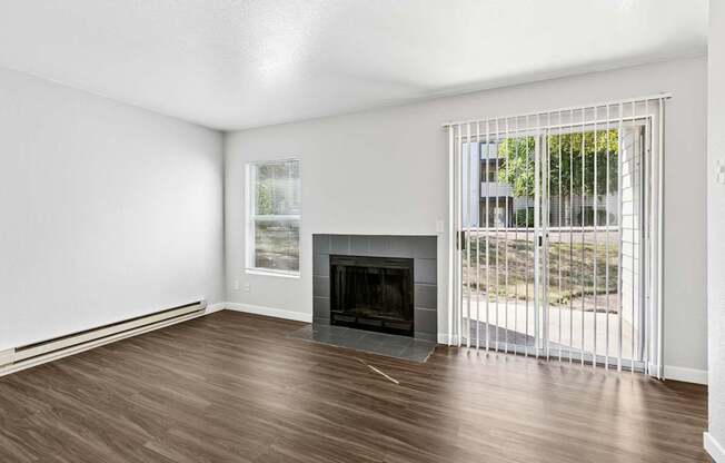 A room with a fireplace and sliding glass doors.
