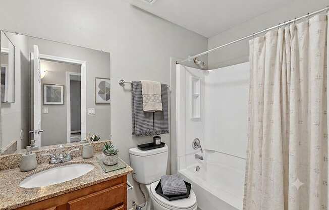 A bathroom with a toilet, sink, and shower.
