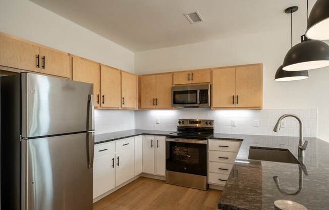 A kitchen with wooden cabinets and a stainless steel refrigerator.