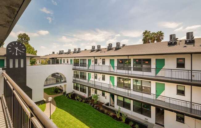 A white building with green trim and a clock tower.