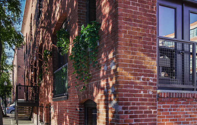 A red brick building with a balcony and a door.