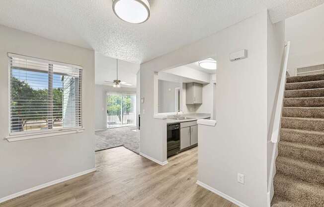 A spacious living room with a staircase leading to the upper floor.