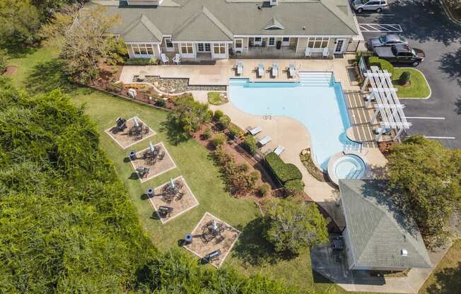 an aerial view of a swimming pool and a house with a yard and a lawn