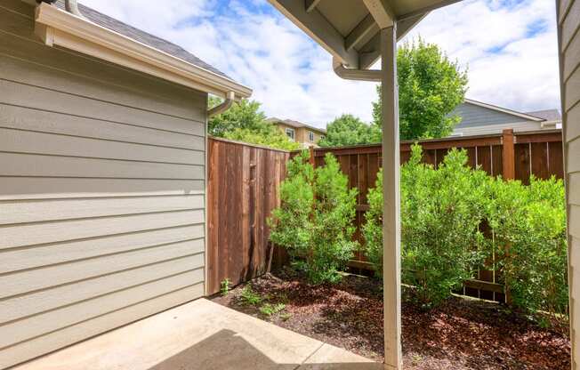 a side view of a house with a yard and a fence