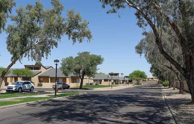 A street view of a residential area with houses and trees.