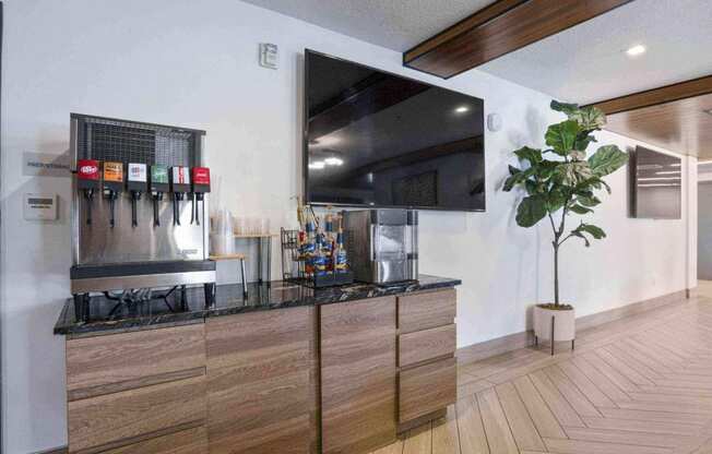 a large flat screen tv hangs above a kitchen countertop at The Flats at Riverwoods, Provo, UT, 84604