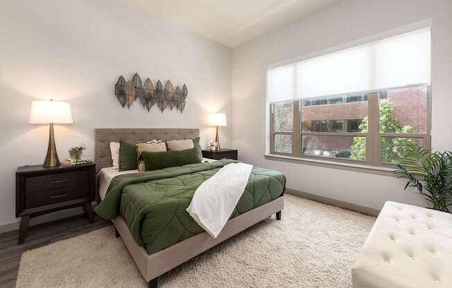 A bedroom with a large bed and a window overlooking a building.