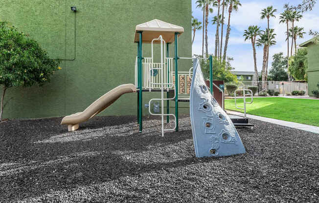 A playground with a slide and a climbing frame.