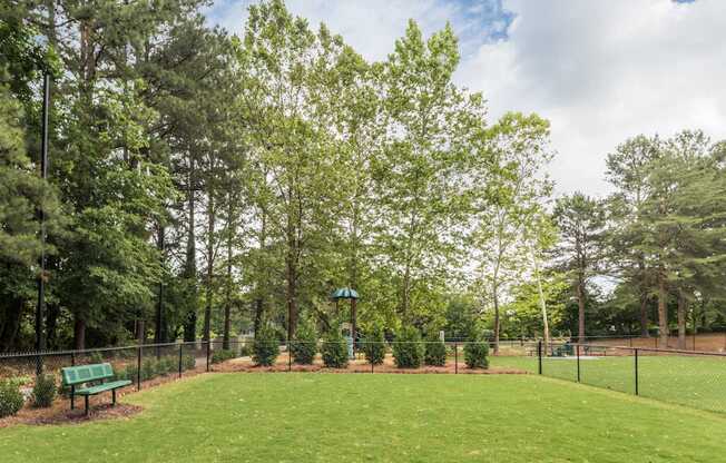 A park with a green bench and trees.