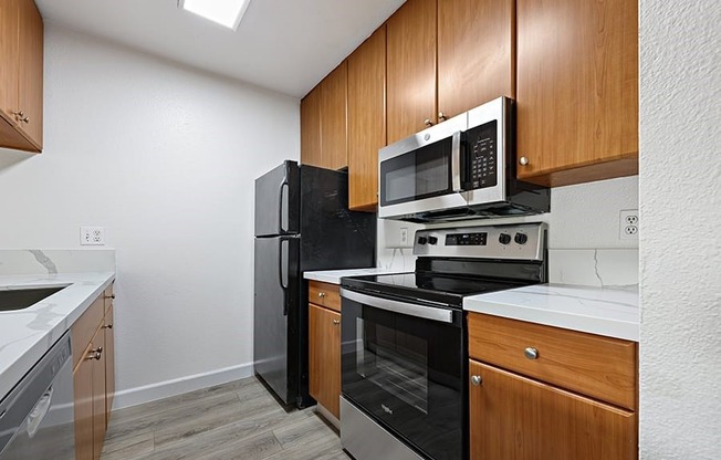 kitchen with vinyl wood like flooring and stainless steel appliances