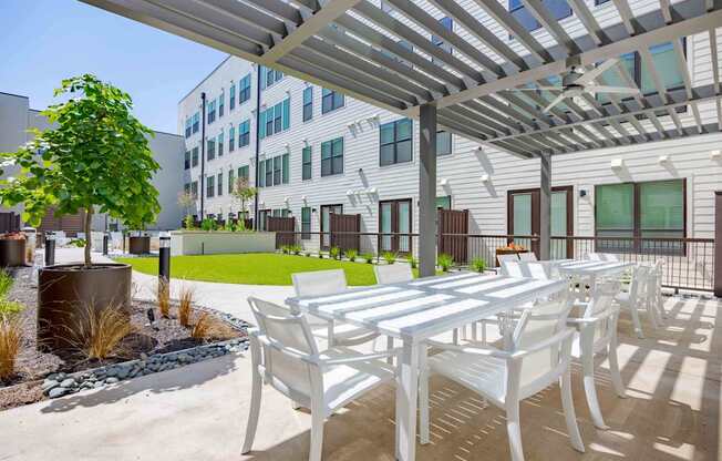 A white table and chairs are set up on a patio.