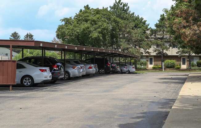 a row of cars parked under a roof in a parking lot at Village Club of Rochester Hills, Shelby Township