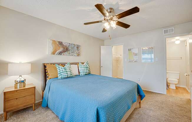 a bedroom with a bed and a ceiling fan