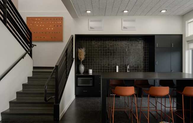a dining room with a table and chairs and a staircase at The Lucy Boise Apartments, Boise, ID