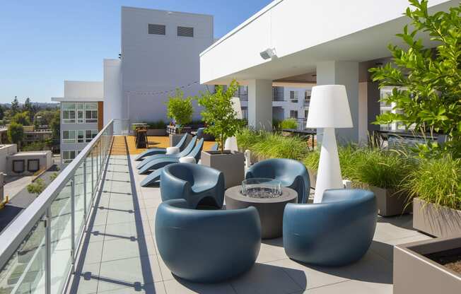 a communal area on the roof of a building with chairs and tables