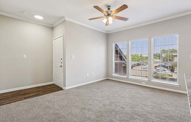 A room with a ceiling fan and carpeted floor.
