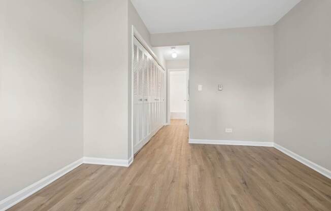 A long hallway with wood floors and white walls.