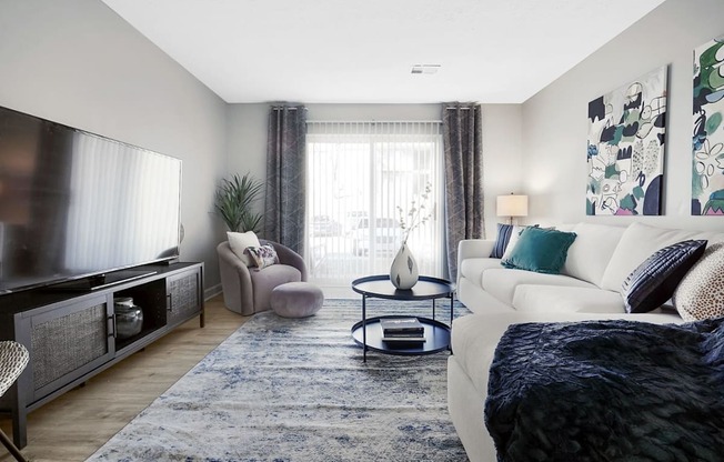 a living room with a white couch and a large tv at Stonewater Apartments, Kentucky