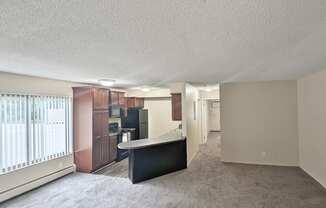 A spacious living room with a black sofa and a television.