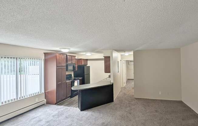 A spacious living room with a black sofa and a television.