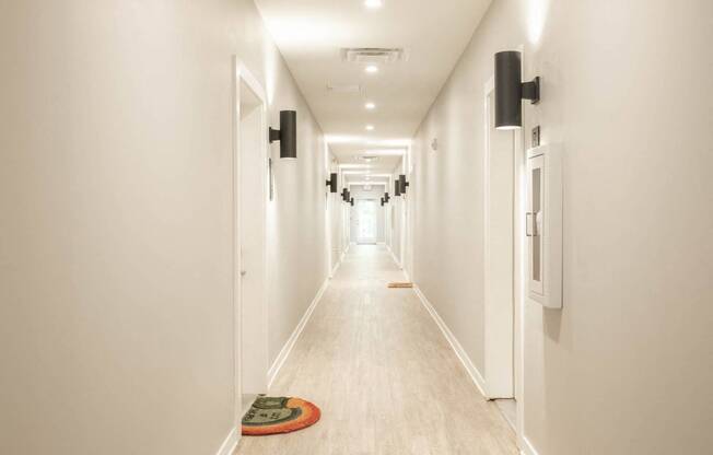 a long hallway with white walls and white floors and white doors