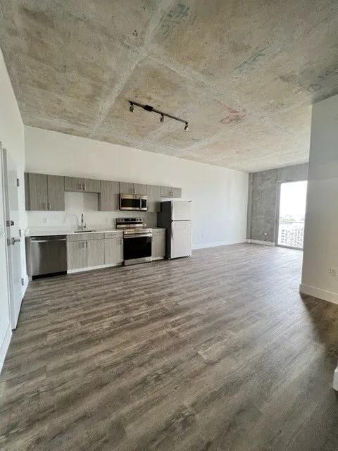 an empty living room with a kitchen in it